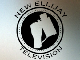 The New Ellijay Television logo. A hand holding an antique camera at an angle